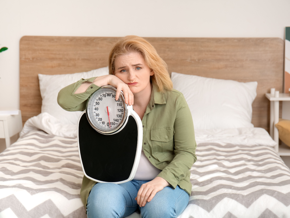 Overweight Woman Holding Weighing Scales